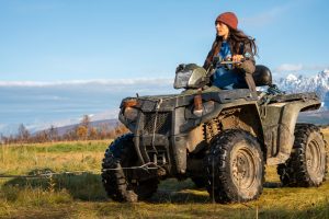 woman driving quad bike in red hat