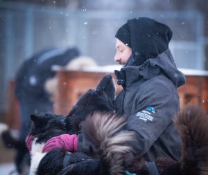 arctic adventure tours dog handler cuddling huskies